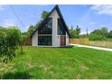 A-frame home featuring modern design, large windows, and a well-kept lawn in a residential area at 7422 New York Ave, Hudson, FL 34667