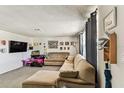Spacious living room featuring a large sectional sofa, plush carpeting, and bright natural light at 7535 Christina Ln, Port Richey, FL 34668