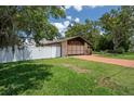 A well-manicured lawn and a driveway that leads to a spacious two-car garage and a white fence on the left at 7630 Landmark Dr, Spring Hill, FL 34606