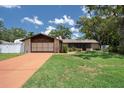 Charming single story home with a well-manicured lawn and a driveway that leads to a spacious two-car garage at 7630 Landmark Dr, Spring Hill, FL 34606