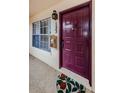 Condo front door with a plum door and a decorative front door mat at 7807 Hardwick Dr # 123, New Port Richey, FL 34653