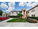 Condo building with a red car in the driveway, lawn and landscaping in front at 7807 Hardwick Dr # 123, New Port Richey, FL 34653
