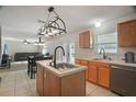 Open concept kitchen with island sink and stainless steel dishwasher overlooking the Gathering room at 8388 Maltby Rd, Spring Hill, FL 34606