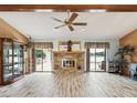 Spacious living room with wood-look floors, a stone fireplace, and sliding glass doors leading to the outdoors at 8393 Delaware Dr, Weeki Wachee, FL 34607