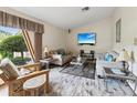 Cozy living room featuring comfortable seating, a large window, and a mounted television at 8393 Delaware Dr, Weeki Wachee, FL 34607
