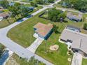 Birds eye view of a home with a lush green lawn surrounded by mature trees in a quiet neighborhood at 9251 Geneva St, Spring Hill, FL 34608