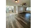 Living room featuring modern flooring, a ceiling fan, and an open view to the kitchen at 10014 Kingswood Ln, Port Richey, FL 34668