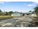 Charming single-story home with a well-maintained lawn, long driveway and decorative landscaping at 1004 Peninsula Ave, Tarpon Springs, FL 34689
