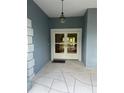 Elegant double front doors with glass inserts, sheltered by a covered porch area with decorative lighting at 10054 Hernando Ridge Rd, Weeki Wachee, FL 34613