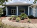 Inviting front entrance with classic columns, decorative landscaping, and a walkway leading to the front door at 10054 Hernando Ridge Rd, Weeki Wachee, FL 34613