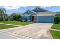 Inviting one-story home featuring a blue exterior, well-kept lawn, extended driveway, and attached two car garage at 1009 Summer Breeze Dr, Brandon, FL 33511