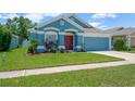 Attractive one-story home boasts a blue exterior, complemented by a vibrant green lawn and neat landscaping at 1009 Summer Breeze Dr, Brandon, FL 33511