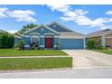 Beautiful one-story home showcases a blue exterior, lush green lawn, and attached two-car garage at 1009 Summer Breeze Dr, Brandon, FL 33511