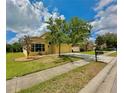 Single-story home with tan exterior, well-maintained lawn, and paved driveway at 11055 Belle Haven Dr, New Port Richey, FL 34654