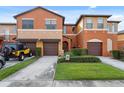 Inviting townhome featuring an attached garage, landscaped yard, and a warm, colorful exterior at 1108 Blackwater Dr, Wesley Chapel, FL 33543