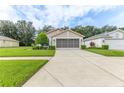 Inviting single-Gathering home featuring mature landscaping, a well-maintained lawn, and a spacious two-car garage at 11158 Heathrow Ave, Spring Hill, FL 34609
