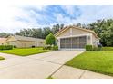 Single-Gathering home with driveway, manicured lawn, and low shrubbery creating inviting curb appeal at 11158 Heathrow Ave, Spring Hill, FL 34609