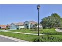 Charming one-story home with lush landscaping, decorative lamp post, and a spacious front yard at 11389 Mcnally Dr, Spring Hill, FL 34609