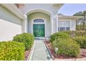 Inviting entrance with a double-door entryway framed by lush greenery and garden lighting at 11389 Mcnally Dr, Spring Hill, FL 34609