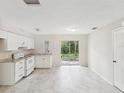 Bright kitchen featuring granite counters, modern appliances, tile flooring, and a view of the trees through sliding glass doors at 11751 Key Lime Dr, New Port Richey, FL 34654