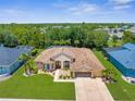 Expansive aerial shot of a well-maintained single-story home surrounded by a lush green lawn and mature trees at 13155 Cori Loop, Spring Hill, FL 34609