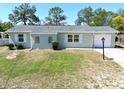 Charming single-story home featuring a well-manicured lawn, windows with white shutters and one-car garage at 13180 Lawrence St, Spring Hill, FL 34609