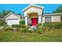 Charming home featuring a beautifully landscaped garden and a vibrant red front door at 13317 Pinellas Ave, Spring Hill, FL 34609