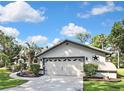 The house has a two-car garage with decorative accents and neatly trimmed bushes lining the walkway and driveway at 13460 Pia Ct, Spring Hill, FL 34609