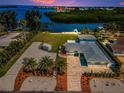 Waterfront property with beach access, manicured lawns, and a modern driveway at 1620 Sea Breeze Dr, Tarpon Springs, FL 34689