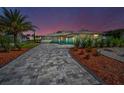 Beautifully landscaped home with an elegant paved driveway and manicured shrubs at 1620 Sea Breeze Dr, Tarpon Springs, FL 34689