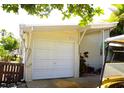 Exterior view of the garage displaying its white door, house number, and golf cart, adding convenience and curb appeal at 20960 Little Magens Loop, Lutz, FL 33558
