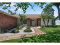 Close up of home's entrance with brick accents, decorative plants, and inviting front door at 2866 Thistle N Ct, Palm Harbor, FL 34684