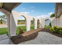 Unique arched entryway with stone and mulch landscaping leading to a well-maintained home at 4424 Whitetail Ln, New Port Richey, FL 34653
