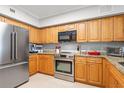 Well-equipped kitchen featuring stainless steel appliances, granite countertops, and natural wood cabinetry at 4516 Seagull Dr # 512, New Port Richey, FL 34652