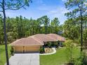 Charming home featuring a three-car garage and landscaped front yard at 4960 Hidden Knob Trl, Spring Hill, FL 34609