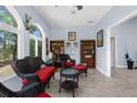 Cozy sunroom featuring wicker furniture, wood-look flooring, and sun-filled windows at 4960 Hidden Knob Trl, Spring Hill, FL 34609