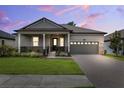 Charming single-story home with a covered front porch, manicured lawn, and two-car garage at 5005 Southern Valley Loop, Brooksville, FL 34601