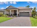 Charming single-story home with a covered front porch, manicured lawn, and two-car garage at 5005 Southern Valley Loop, Brooksville, FL 34601