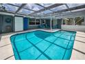 Enclosed pool offering a serene escape with outdoor seating and lush surroundings at 5132 Flora Ave, Holiday, FL 34690
