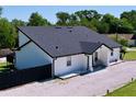 Side exterior view of a white home with a dark roof, black trim, and gravel yard at 6158 Sumter Dr, Brooksville, FL 34602