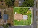 An aerial view showcases this home's lush, green lawn, mature trees, and landscaping at 6823 Oak Hill Dr, New Port Richey, FL 34653
