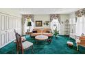 Cozy living room features vintage décor, including floral curtains and a plush green carpet at 6823 Oak Hill Dr, New Port Richey, FL 34653