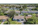 An aerial view showcases this charming single-story house surrounded by mature trees in a well-established neighborhood at 6989 300 Th N Ave, Clearwater, FL 33761