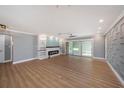 Bright open living room featuring wood floors, a modern fireplace, custom shelving, and sliding glass doors at 6989 300 Th N Ave, Clearwater, FL 33761