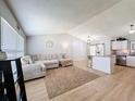 Spacious living room featuring an oversized couch, modern flooring, and an open floorplan at 7979 Avenal Loop, New Port Richey, FL 34655