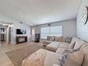 Inviting living room featuring a sectional couch, stylish decor, and an open layout at 7979 Avenal Loop, New Port Richey, FL 34655