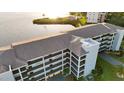 Aerial view of condo building featuring lush landscaping and covered parking at 8211 Brent St # 836, Port Richey, FL 34668