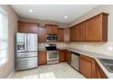 Modern kitchen featuring stainless steel appliances, wooden cabinets, and tile backsplash at 8409 Blue Rock Dr, New Port Richey, FL 34653