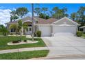 Charming single-story home with lush landscaping, well-manicured lawn, and a two-car garage under a beautiful blue sky at 9019 Flagstick Ln, Hudson, FL 34667