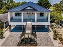 Beautiful two-story home with a metal roof, inviting porch and well-designed landscaping at 111 E Cedar St, Tarpon Springs, FL 34689